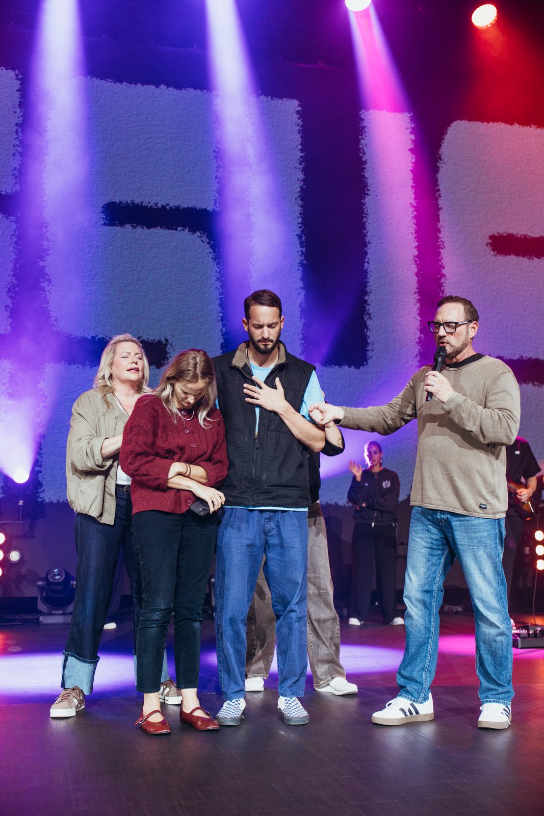 Bob and Erica Hazlett praying with a young couple